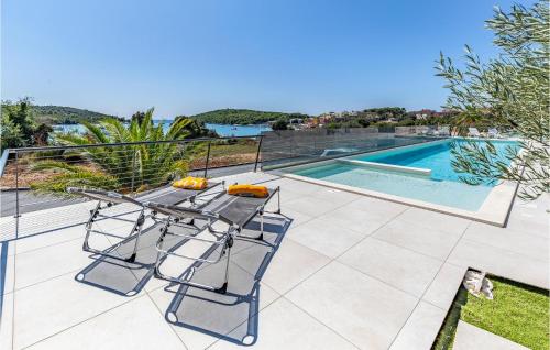 a patio with a table and chairs next to a swimming pool at Cozy Apartment In Banjole in Banjole