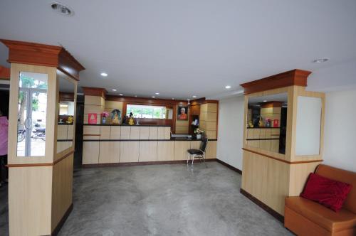 a large room with a kitchen and a bar at Phoonsab Hostel in Phitsanulok