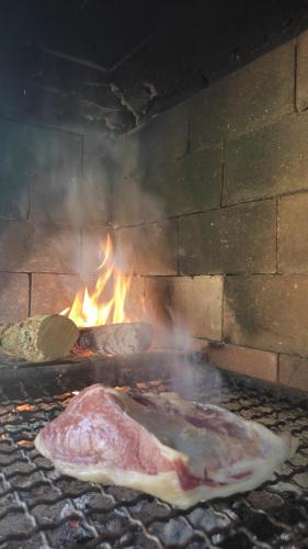 two pieces of meat cooking in a brick oven at La Celeste in La Granja