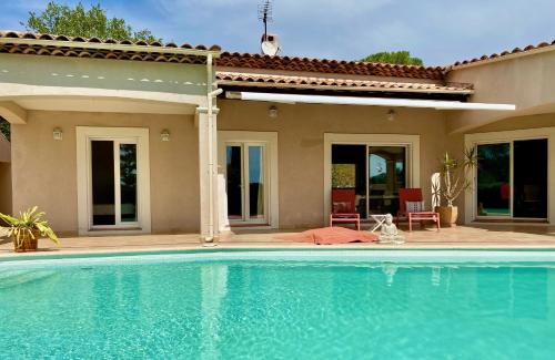 une piscine devant une maison dans l'établissement Magnifique villa avec piscine en Provence Verte, à La Roquebrussanne