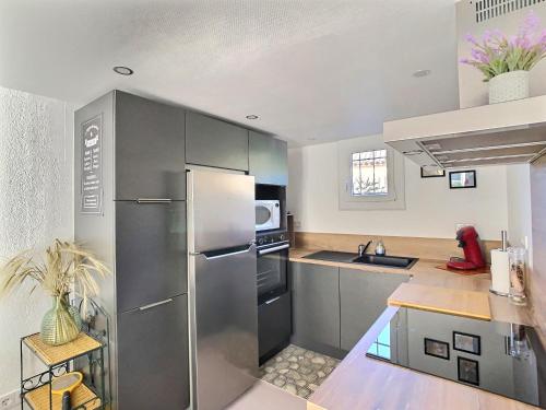 une cuisine avec un réfrigérateur en acier inoxydable et un évier dans l'établissement Maison Luxembourgeoise à Vias, à Vias