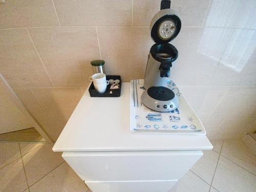 a clock sitting on top of a white table at Gastenkamers Centersuites in Oostduinkerke