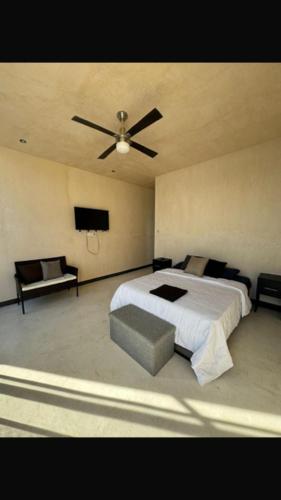 a bedroom with a bed and a ceiling fan at Villa Colibríes in Chelem