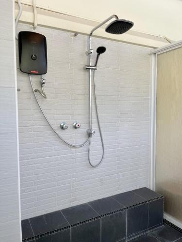 a shower with a hose attached to a wall at Kaba Home Melaka in Melaka