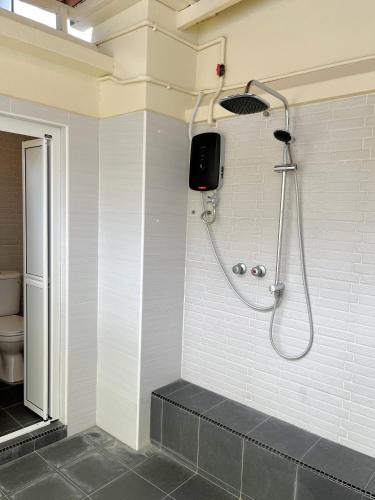 a bathroom with a shower in a white wall at Kaba Home Melaka in Melaka