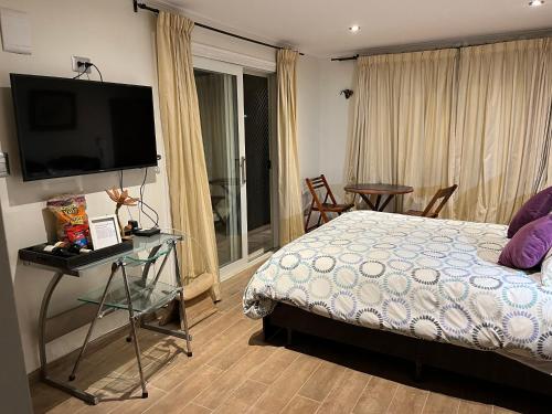 a bedroom with a bed and a flat screen tv at Loma de las Maravillas 2 in Curacaví