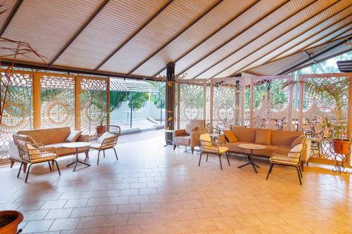 a living room with couches and chairs and windows at Senegambia Beach Hotel in Kololi