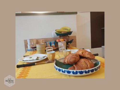a table with a plate of loaves of bread on it at Elmas Room in Elmas