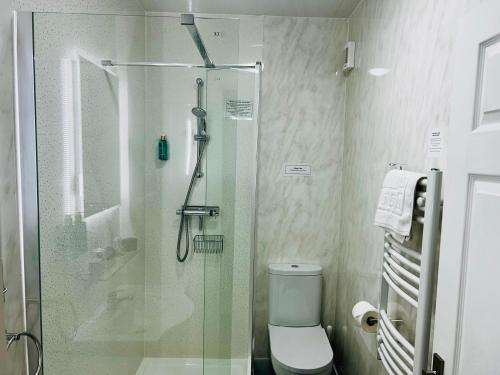 a bathroom with a glass shower with a toilet at Hotel No5, Beachfront with Free Private Car Park in Llandudno