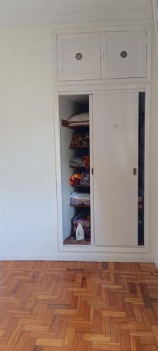 a kitchen with a white cabinet and a wooden floor at Apto no Centro de Petrópolis in Petrópolis