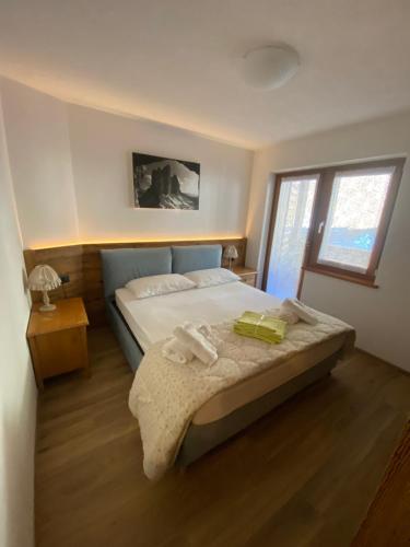 Un dormitorio con una cama grande y una ventana. en Casa del bosco, en Canazei