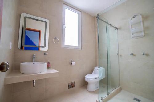 a bathroom with a toilet and a sink and a shower at MRE Goldsmith Polanco in Mexico City