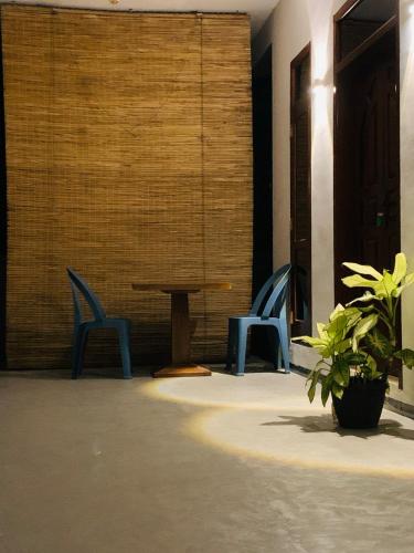 zwei blaue Stühle und ein Tisch in einem Zimmer in der Unterkunft La fiesta in Weligama