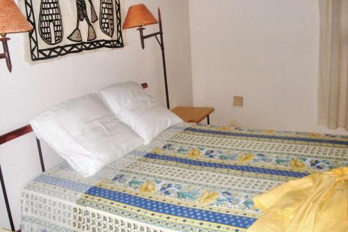 a bedroom with a bed with a quilt on it at Charming house with private pool in Cap Skirring in Cap Skirring