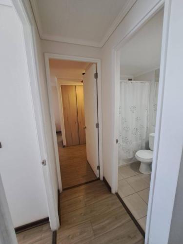 an empty bathroom with a toilet and a hallway at Cómodo Dpto Calama Centro in Calama