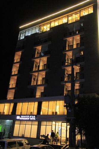a tall building with people standing in front of it at Nahusenay hotel in Addis Ababa