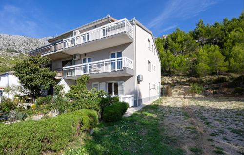 a large white house on a hill with trees at Apartment Vojskovo Croatia in Lokva Rogoznica