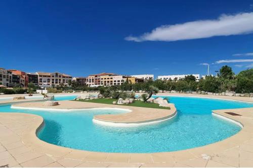 - une piscine d'eau bleue dans un complexe dans l'établissement La Siesta 6 Personnes Bord de Plage et Piscine, terrasse de 30m2, à Gassin