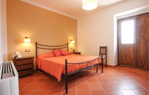a bedroom with a bed with orange sheets and a window at Lovely Home In Rutino With Kitchen in Rutino