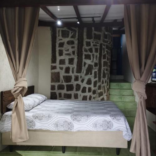 a bedroom with a large bed with curtains at Bangalô Vista Azul in Ilhabela