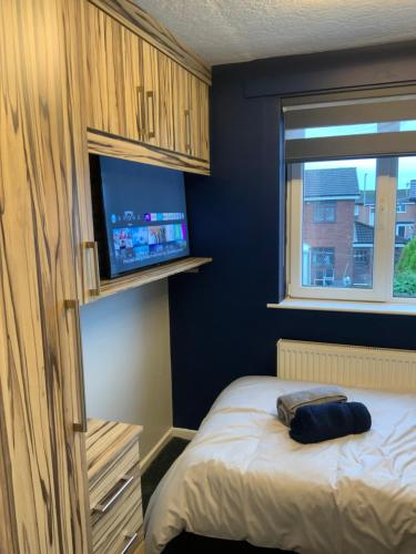 a bedroom with a bed and a tv on a wall at The Nest - Cosy Rooms in Harwood