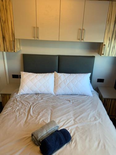 a bed with two towels sitting on top of it at The Nest - Cosy Rooms in Harwood