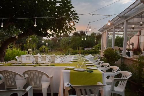 a long table with white chairs and a white table cloth at Al Passo di Thalia in Ricadi
