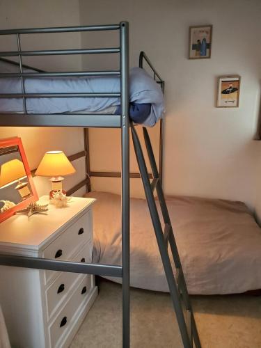 - une chambre avec 2 lits superposés et un bureau avec une lampe dans l'établissement Maison carcans maubuisson lac et océan, à Carcans