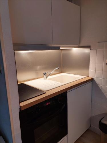 Il comprend une petite cuisine avec un évier et un comptoir. dans l'établissement Maison carcans maubuisson lac et océan, à Carcans