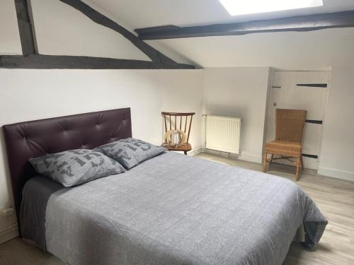 une chambre avec un grand lit et une chaise dans l'établissement Charmante dépendance, à Izon