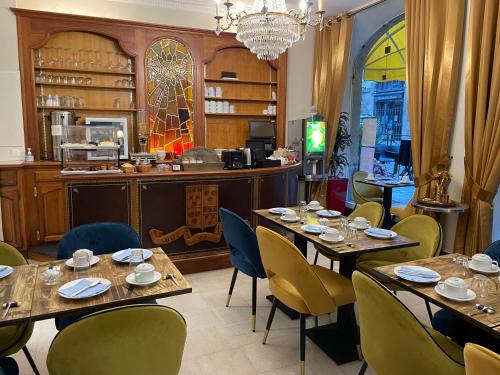 a restaurant with tables and chairs and a chandelier at Balzac Hôtel Restaurant in Fougères