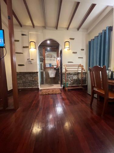 a living room with a wooden floor and a bedroom at Chaluenxay Legend Hotel in Luang Prabang