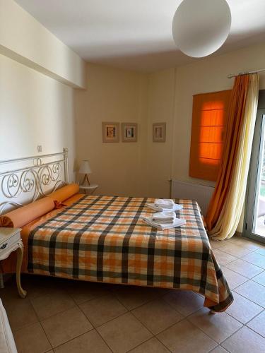 a bedroom with a bed with a checkered blanket at Erofili Villas in Lourdata