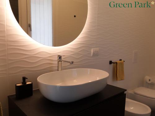 a bathroom with a large white sink and a mirror at Green Park Rooms in San Donato Milanese