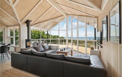 a large living room with a large couch and windows at Holiday Home Klitvej Ebeltoft X in Ebeltoft