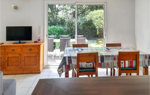 une salle à manger avec une table, des chaises et une télévision dans l'établissement 3 Bedroom Beautiful Home In Erquy, à Erquy