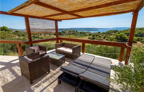 Un patio con una mesa y sillas en una terraza. en Lovely Home In Banjol With Sauna, en Banjol