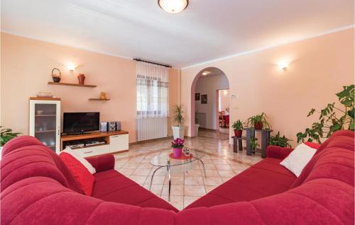 a living room with a red couch and a tv at Holiday Home Krse V in Premantura