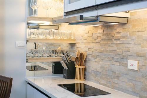 a kitchen with a counter with glasses on the wall at Carpe Diem Staycation in Mactan Island
