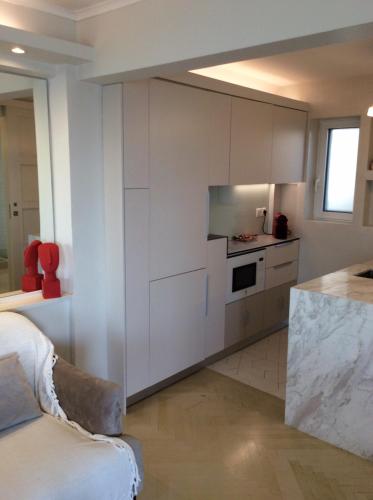 a kitchen with white cabinets and a counter at kolonaki Penthouse panoramic Acropolis view in Athens