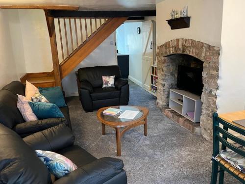 a living room with a couch and a fireplace at Cottage in Wells in Wells