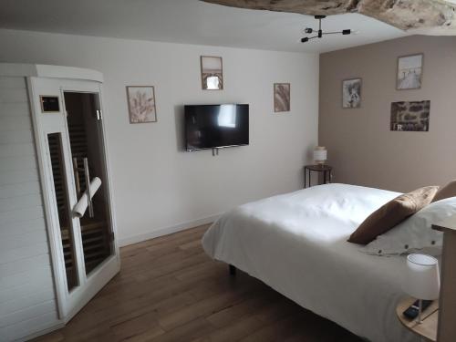 a bedroom with a bed and a tv on the wall at La vie est belle in Domjean