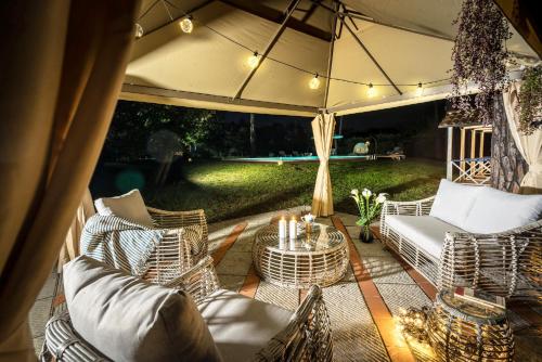 a patio with chairs and a table and an umbrella at Villa Ines charme near Lucca in Altopascio