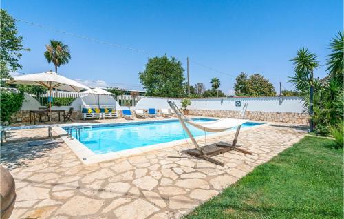 a swimming pool with a hammock in a yard at 2 Bedroom Cozy Home In Sabaudia in Sabaudia
