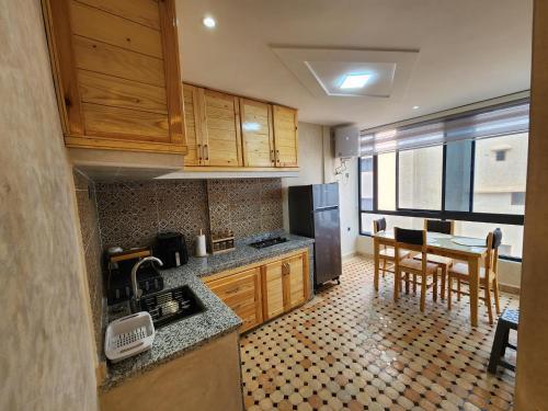 a kitchen with wooden cabinets and a table and chairs at Tirazir House 4 in Mirleft