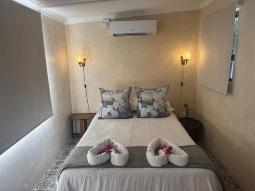 a bedroom with a bed with two towels on it at Boutique by Beach Collection in Strand