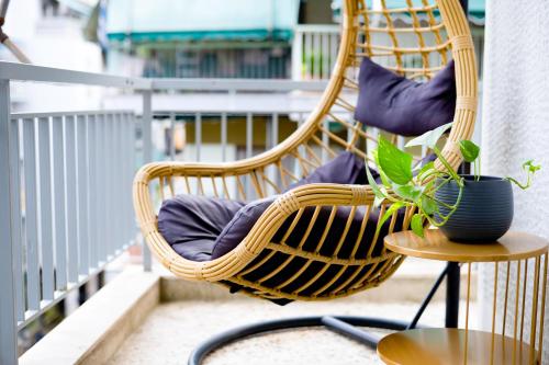 a wicker rocking chair on a balcony with a plant at The Parthenon Porch for Familys & Groups , 4BR ! in Athens