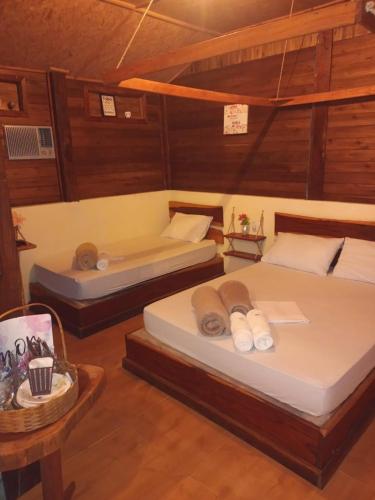 a room with two beds and a table at Chalé Refúgio Encantado 2 in Eldorado