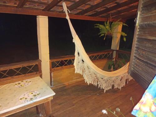 a hammock on a porch of a house at Chalé Refúgio Encantado 2 in Eldorado