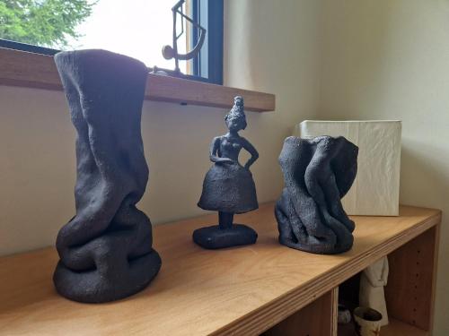 a shelf with two black statues on top of it at Holzhaus mit Kamin - Am Forellenfluss in Heinersdorf